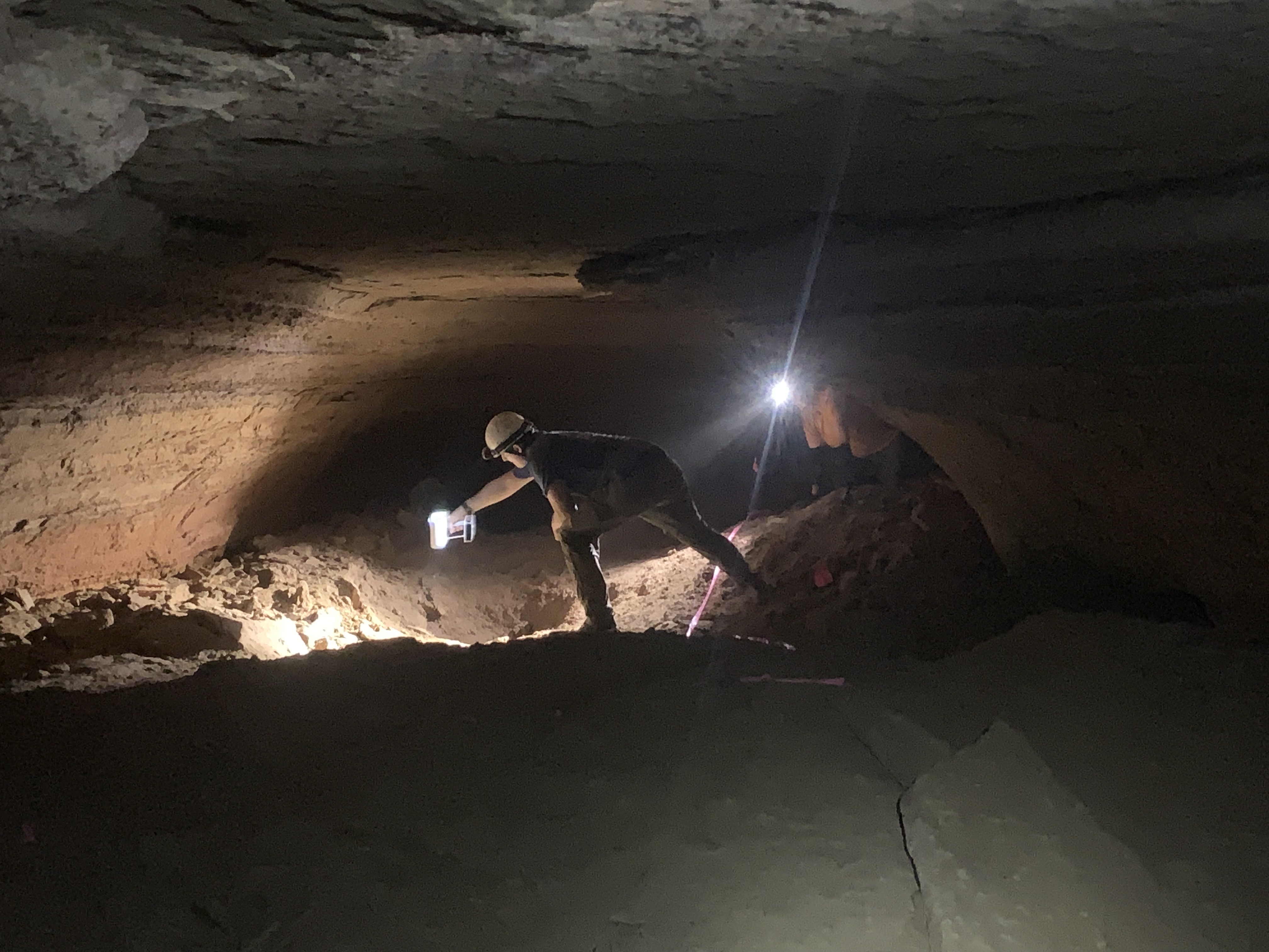 James Keppeler operating a handheld 3D scanner over human trackways on the floor of Helms Deep Cave, lit by headlamp